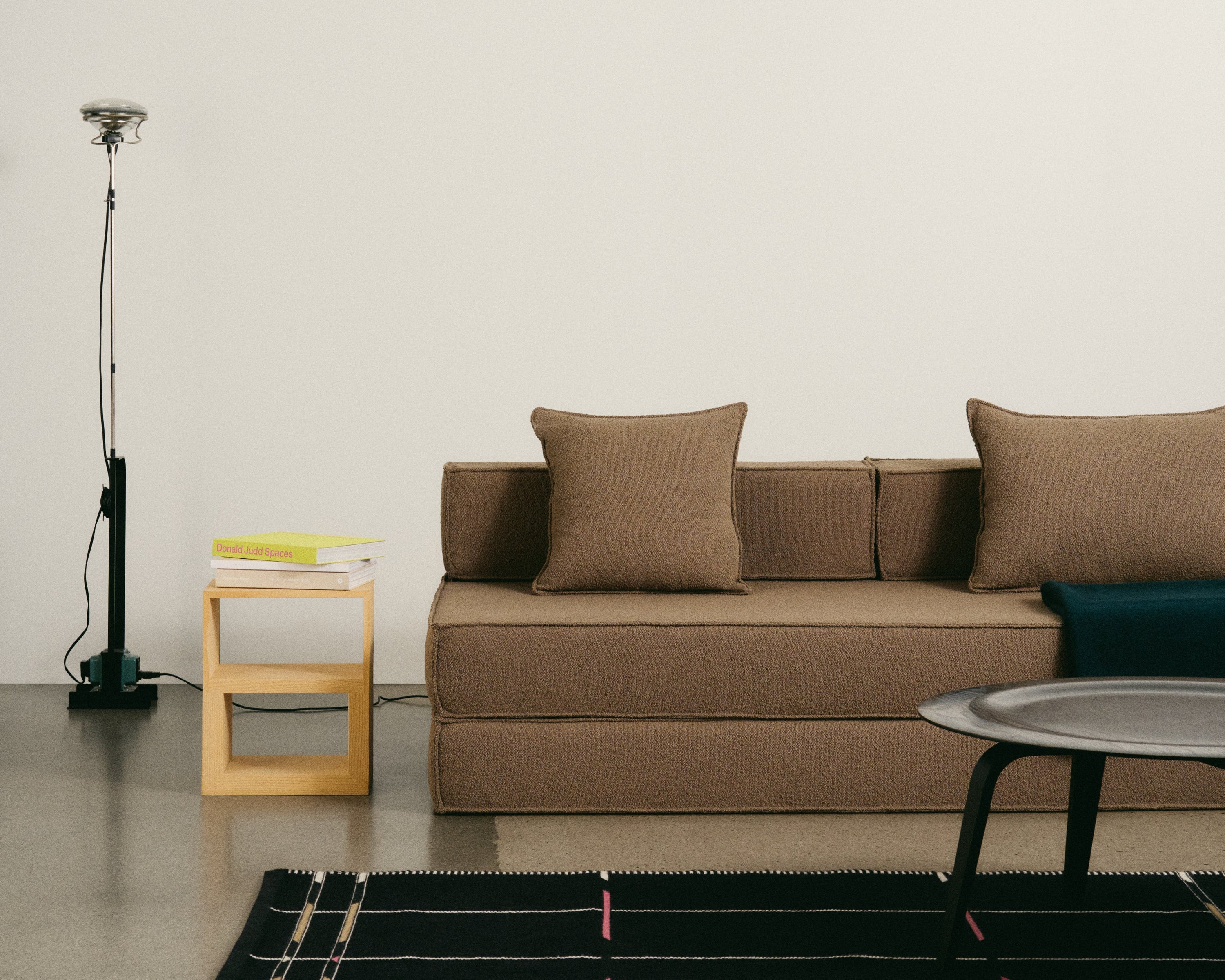 Modern living room with a brown sofa, rug, and side table.